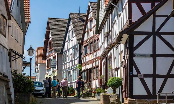 Fachwerkhäuser bei Sonnenschein und eine kleine Gruppe von Menschen