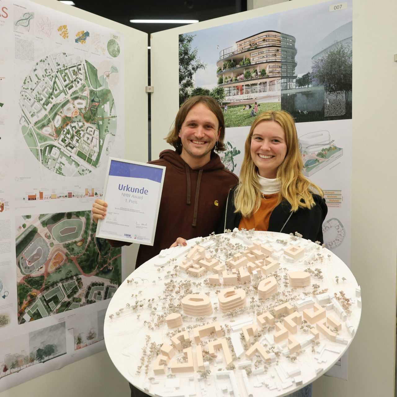 Celina Ebbert und Paul Fleckenstein überzeugten die Jury mit ihrem Projekt OSTKAS. Im Vordergrund ihr Modell, im Hintergrund ausgearbeitet auf einer Plakatwand.