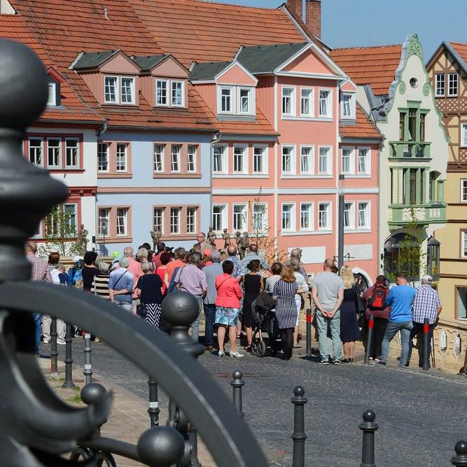 Eine Gruppe von Menschen besichtigt eine historische Altstadtkulisse