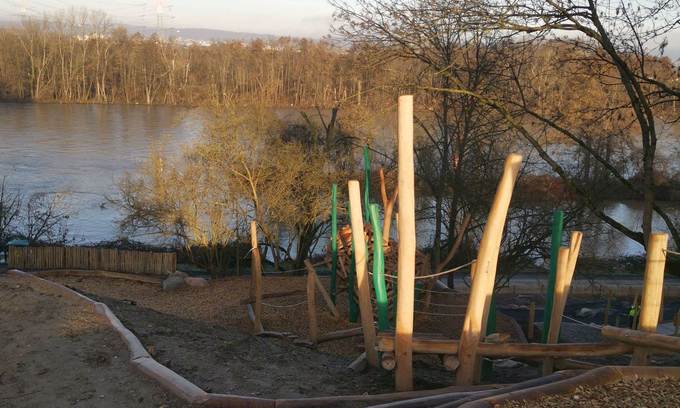 Spielplatz mit Kletter- und Balancierelementen, im Hintergrund der Main