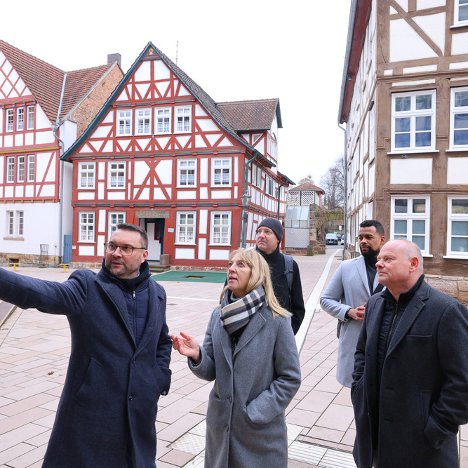 (v.li.) Hofgeismars Bürgermeister Torben Busse, Karin Jasch vom Hessischen Wirtschaftsministerium und Ulrich Türk, Leiter FB Stadtentwicklung Nord bei der ProjektStadt. Im Hintergrund Fachwerkhäuser.